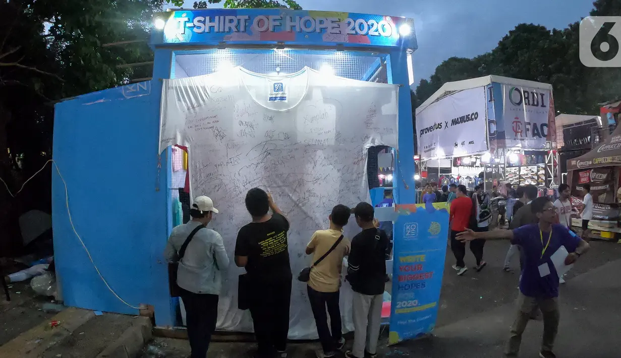 Sebuah kaus putih berukuran 3x3.1 meter menghiasi booth Koze Indonesia pada JakCloth Year End Sale 2019 di Plaza Tenggara GBK Senayan, Jakarta, Kamis (26/12/2019). Pengunjung membubuhkan tanda tangan dan harapan di tahun 2020. (Liputan6.com/Fery Pradolo)