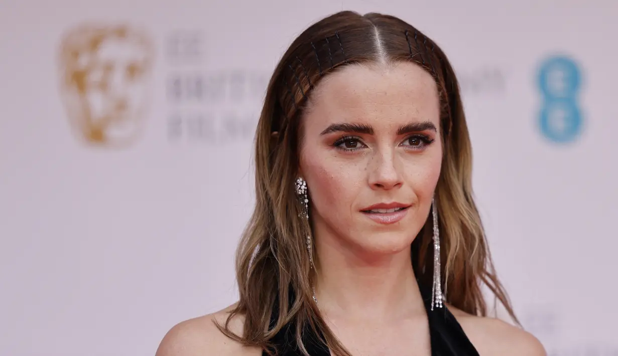 Aktris Inggris Emma Watson berpose di karpet merah saat tiba di BAFTA British Academy Film Awards di Royal Albert Hall, di London (13/3/2022). Emma Watson tampil memesona dengan atasan halter-neck hitam dan rok tulle krem. (AFP/Tolga Akmen)