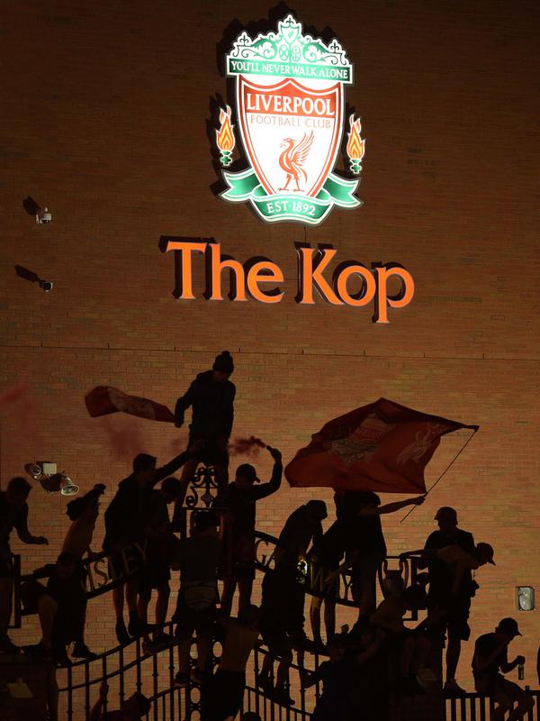 Para fans merayakan Liverpool memenangkan gelar juara Liga Primer Inggris di luar stadion Anfield di Liverpoo (25/6/2020). Liverpool meraih mahkota juara Liga Premier Inggris setelah mengakhiri gelar selama 30 tahun penantian.  (AFP Photo/Oli Scarff)