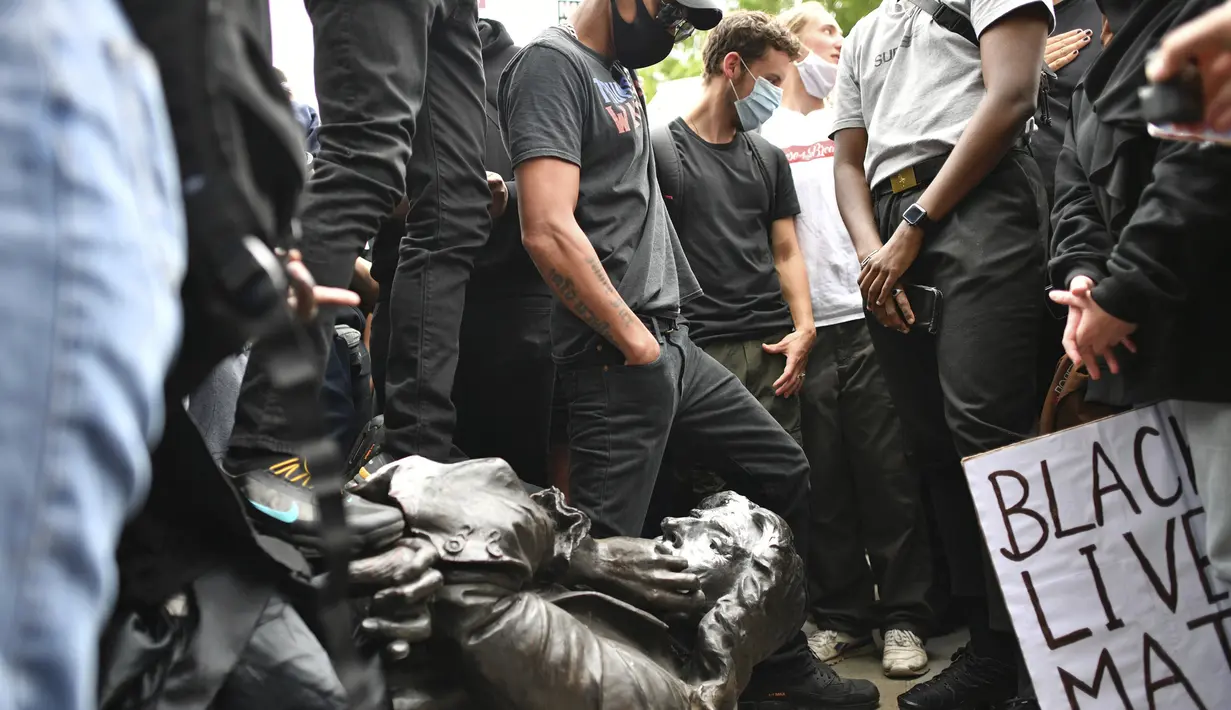 Demonstran merobohkan patung pedagang budak Edward Colston saat protes Black Lives Matter di Bristol, Inggris, Minggu (7/6/2020). Aksi tersebut dilakukan sebagai bentuk protes atas kematian George Floyd saat ditangkap oleh polisi di Amerika Serikat. (Ben Birchall/PA via AP)