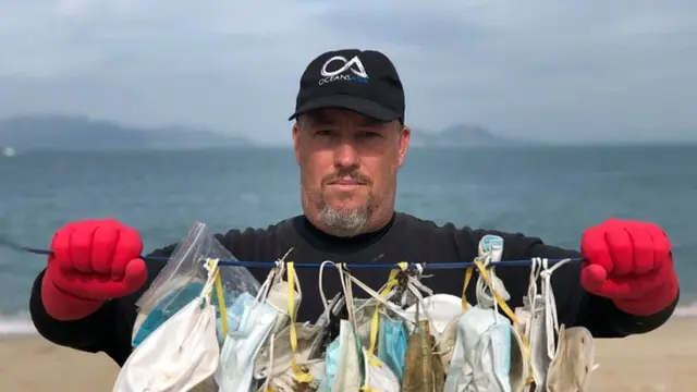 Potret Gary Stokes Memegang Limbah Masker yang Ditemukan di Sepanjang Garis Pantai