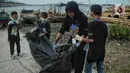 Anak-anak pesisir dan sukarelawan saat membersihkan sampah di Pemukiman Nelayan Manunggal, Cilincing, Jakarta Utara, Minggu (18/9/2022). Tumpukan sampah yang berserakan di kawasan pemukiman nelayan Manunggal, Cilincing menginisasi Kelas Jurnalis Cilik untuk membersihkan sampah dan mengedukasi kepada anak-anak pesisir serta masyarakat pentingnya menjaga kebersihan di lingkungan sekitar. (merdeka.com/Iqbal S. Nugroho)