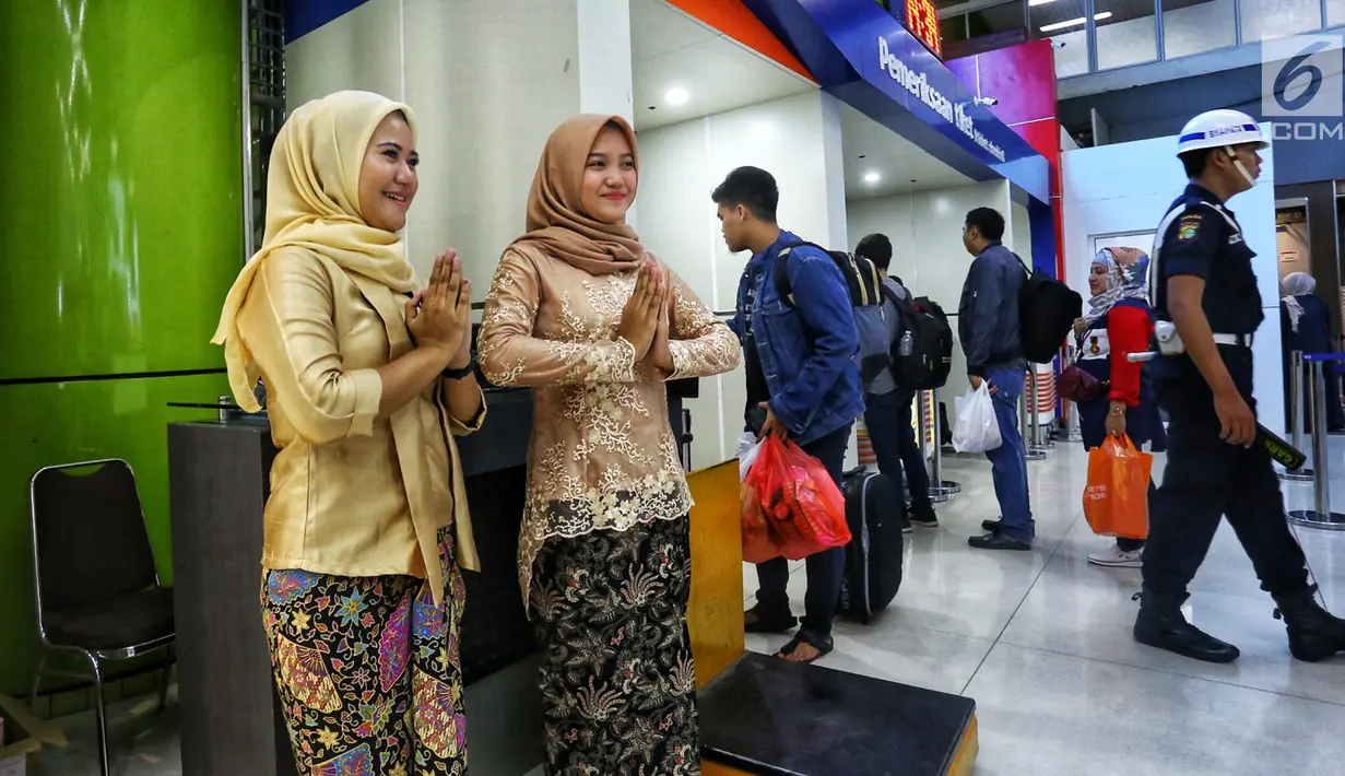 Petugas frontliner berpakaian tradisional menyambut calon penumpang di Stasiun Gambir, Jakarta, Minggu (21/4). PT KAI Daop 1 Jakarta mewajibkan petugas frontliner wanita dan pria mengenakan kebaya dan batik untuk menyambut Hari Kartini. (Liputan6.com/Johan Tallo)