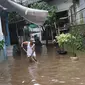 Warga membersihkan banjir yang menggenangi kawasan Cilandak Timur, Jakarta Selatan, Selasa (22/1). Hujan deras yang mengguyur Jakarta dan sekitarnya sejak pagi menyebabkan banjir di sejumlah sudut Ibu Kota. (Liputan6.com/Immanuel Antonius)