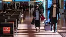 <p>Penumpang berjalan melalui aula kedatangan di Bandara Internasional Haneda Tokyo, Jumat (18/2/2022). Pemerintah Jepang mengumumkan rencana untuk melonggarkan aturan perbatasan virus bagi pekerja dan pelajar. (AFP/Philip Fong)</p>
