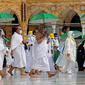 Jemaah yang memegang payung untuk melindungi diri dari panas tiba di Masjidil Haram pada awal musim haji, Arab Saudi, Sabtu (17/7/2021). Pemerintah Arab Saudi mengklaim ibadah haji tahun lalu hanya diikuti 1.000 orang, sementara media lokal menyebut ada 10 ribu orang. (FAYEZ NURELDINE/AFP)