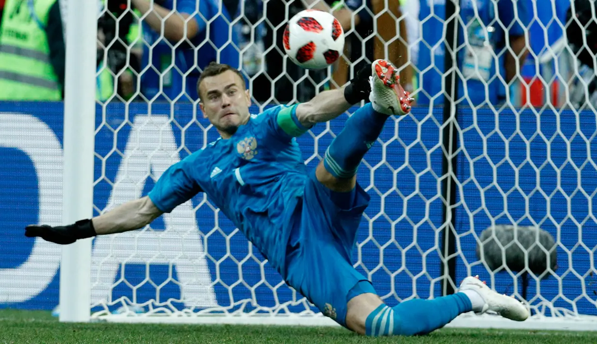 Kiper Rusia, Igor Akinfeev menahan tendangan penalti timnas Spanyol pada babak 16 besar Piala Dunia 2018 di Stadion Luzhniki, Minggu (1/7). Rusia lolos ke perempat final setelah menang adu penalti 4-3 atas Spanyol. (AP/ Victor R. Caivano)