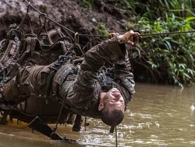 Tentara dari Combat Team Divisi Infanteri 1 Stryker Brigade Angkatan Darat AS melintasi sungai dengan tali dalam pelatihan perang hutan di Hawaii, 1 Maret 2017. Tentara melakukan kursus pelatihan hutan untuk fokus pada Asia dan Pasifik. (AP/Daniel Lin)