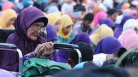 Tampak seorang ibu dalam kursi roda begitu khusyu ketika melakukan doa bersama di acara Istighasah yang bertajuk "Munajat Bangsa Untuk Pemilu" di Lapangan Timur, Monas, Minggu (9/3) (Liputan6.com/Andrian M Tunay).