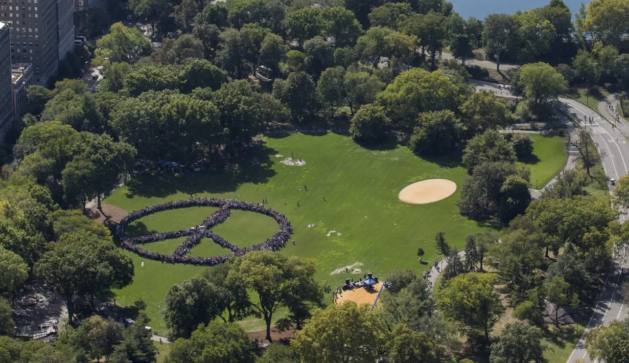 Ribuan orang mencoba memecahkan rekor dunia untuk rantai manusia terpanjang dalam bentuk tanda perdamaian di New York Central Park, Selasa (6/10). Kegiatan itu menandai ulang tahun John Lennon ke-75. (REUTERS/NYonAir/Paul GaNun)