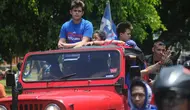 Cristian Gonzales dan keluarga naik jip warna merah saat arak-arakan Arema FC juara Piala Presiden 2017. (Bola.com/Iwan Setiawan)