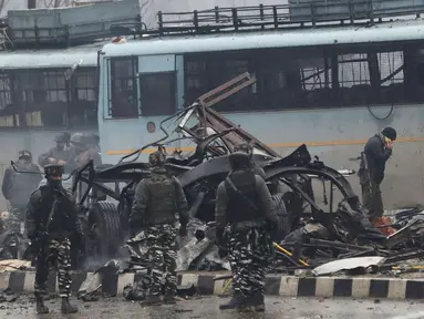 Tentara India memeriksa puing-puing setelah ledakan bom mobil di Lethpora di distrik Pulwama, Kashmir, India (14/2). Sedikitnya 16 tentara India tewas dan 20 orang terluka akibat kejadian tersebut. (AFP Photo/STR)