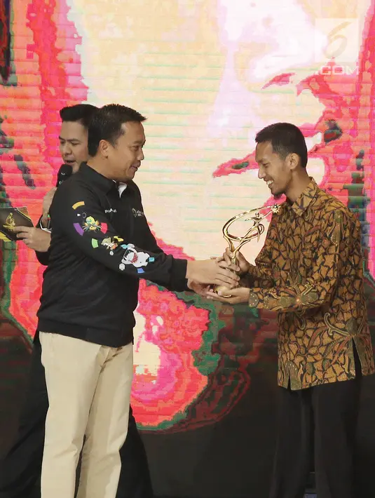 Menpora Imam Nahrawi memberikan piala kepada Nofi Bayu Darmawan dalam Kategori Inovasi saat ajang Liputan6 Awards 2018 di SCTV Tower, Jakarta, Minggu (20/5). (Liputan6.com/Herman Zakharia)