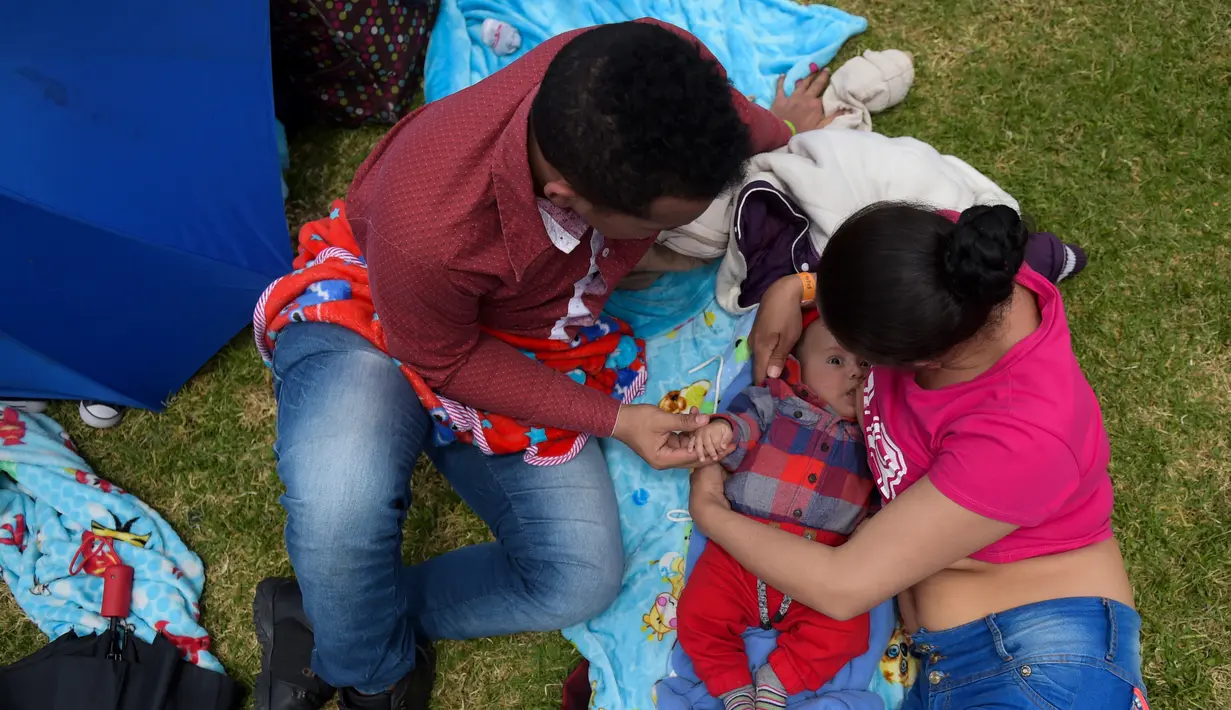 Seorang wanita menyusui anaknya didampingi suaminya selama Pekan Menyusui Dunia di taman Los Novios, Bogota, Kolombia, (3/8). Pekan Menyusui Sedunia diikuti lebih dari 170 negara. (AFP Photo/Raul Arboleda)