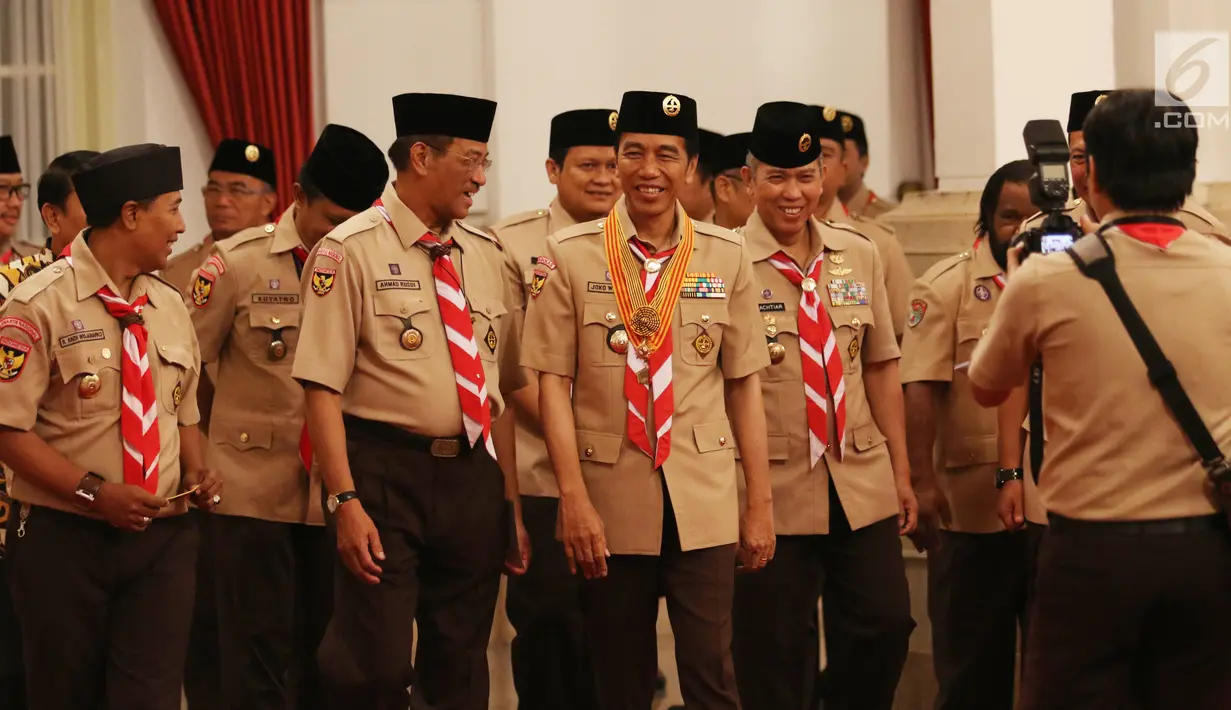 Presiden Joko Widodo berbincang dengan Ahmad Rusdi saat upacara pelepasan Kontingen Gerakan Pramuka Indonesia di Istana Negara, Jakarta, Jumat (19/7/2019). Pramuka Indonesia akan terbang ke Virginia Barat untuk menghadiri Jambore Pramuka Dunia XXIV. (Liputan6.com/Angga Yuniar)