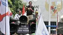 Seorang buruh menyampaikan orasi saat menggelar unjuk rasa di depan Gedung Ketenagakerjaan, Jakarta, Rabu (24/10). Dalam aksinya, para buruh menyuarakan tuntutan kenaikan Upah Minimum 2019 sebesar 20-25 persen. (Merdeka.com/Iqbal S. Nugroho)