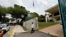 Seorang staf berjalan keluar memeriksa saat polisi Malaysia ditempatkan di depan Kedutaan Besar (Kedubes) Korea Utara di Kuala Lumpur, Selasa (7/3). Pemerintah Malaysia melarang staf Kedubes Korut keluar dari Negeri Jiran. (AP Photo/Vincent Thian)