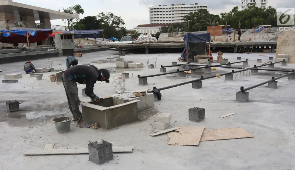 Pekerja melakukan pengerjaan revitalisasi Taman Lapangan Banteng, Jakarta Pusat, Rabu (7/3). Revitalisasi Taman Lapangan Banteng ditargetkan rampung pada akhir Maret 2018. (Liputan6.com/Arya Manggala)