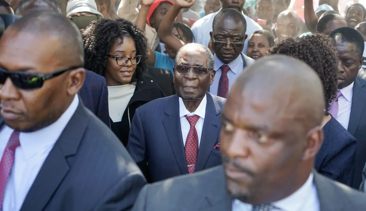Mantan Presiden Zimbabwe, Robert Mugabe tiba untuk memberikan suara dalam pemilihan umum negara itu di TPS distrik Highfield, Harare, Senin (30/7). Mugabe tidak melontarkan komentar saat masuk ke dalam tempat pemungutan suara. (AFP/Zinyange AUNTONY)