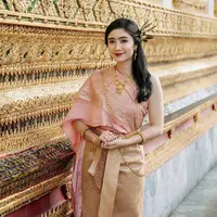 Ia mengenakan pakaian tradisional Thailand yang disebut dengan chut thai. Febby mengenakan chut thai atasan pink dipadukan bawahan mirip songket warna coklat. [Instagram/@febbyrastanty]