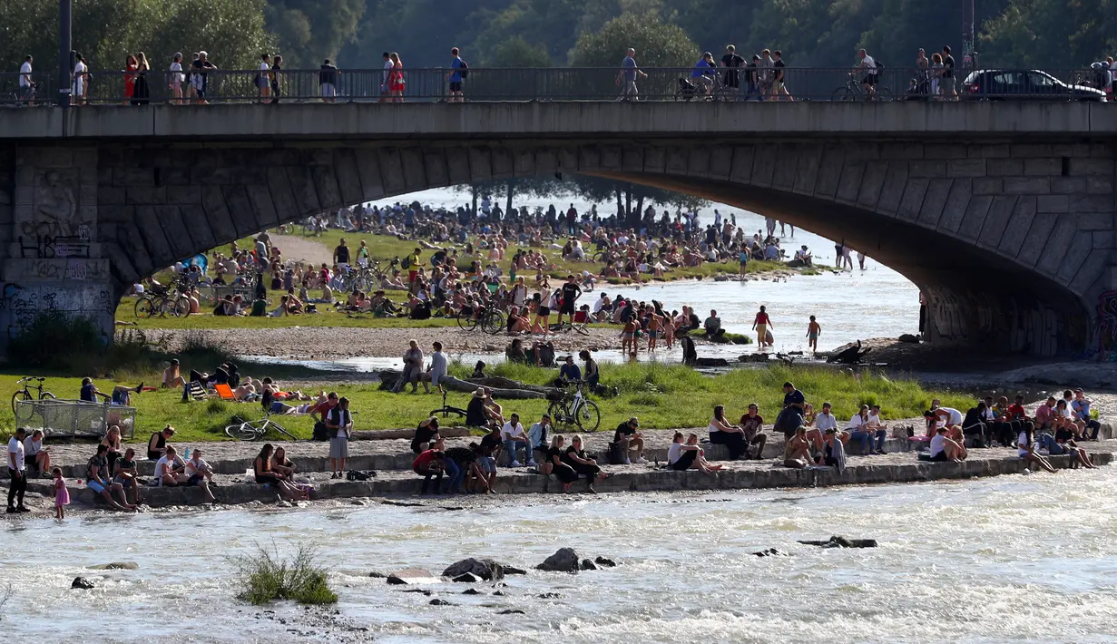 Ribuan orang menikmati cuaca musim panas di tepi sungai 'Isar' di Munich, Jerman (19/7/2020). Di tengah pandemi COVID-19, ribuan orang menikmati cuaca musim panas di dekat sungai tersebut untuk berjemur serta mendinginkan tubuh. (AP Photo/Matthias Schrader)