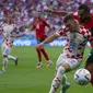 Pemain Timnas Kroasia, Josip Juranovic (kiri) berebut bola dengan pemain Timnas Maroko, Sofiane Boufal dalam laga matchday pertama Grup F Piala Dunia 2022 di Al Bayt Stadium, Qatar, Rabu (23/11/2022) sore WIB. (AP/Thanassis Stavrakis)