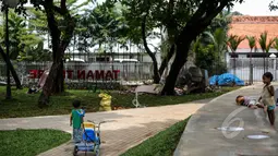 Sejumlah anak kecil terlihat bermain disela proyek pembangunan Ruang Publik Terpadu Ramah Anak (RPTRA) di Jalan Tidore RW 05, Kelurahan Cideng, Gambir, Jakarta, yang sempat terhenti sementara, Senin (4/5/2015). (Liputan6.com/Faizal Fanani)