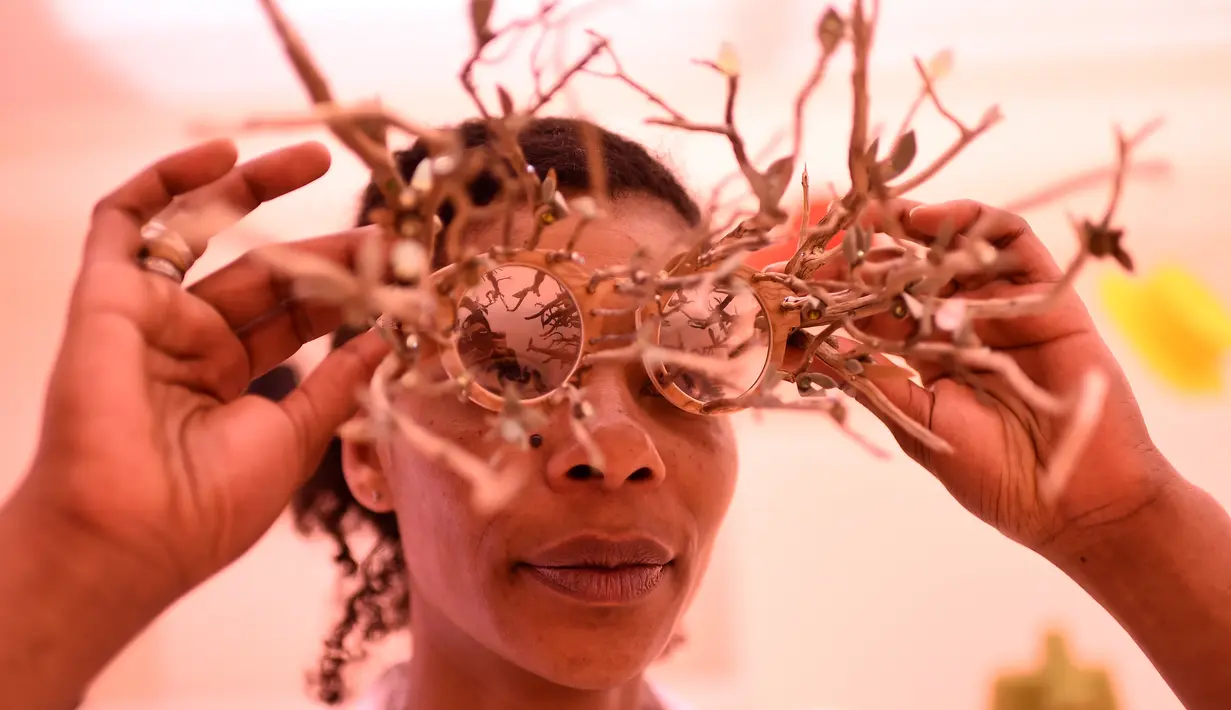Perancang asesoris asal Prancis Sandrine Paskusz-Koffi menampilkan model kacamata unik berbentuk ranting saat Hyères International Festival of Fashion and Photography 2017, Prancis, Jumat (28/4). (AFP PHOTO / ANNE-CHRISTINE POUJOULAT)