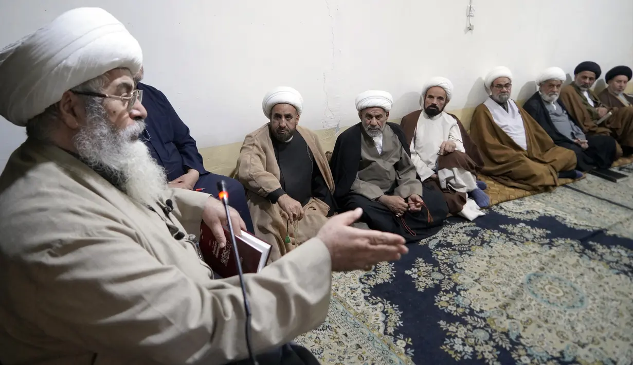Ulama Syiah Nuri al-Saedi (kiri) berbicara kepada murid-muridnya selama pelajaran di kota suci Najaf, Irak, 23 November 2021. Sekolah-sekolah agama di Irak kembali dibuka setelah lebih dari dua tahun di tengah pandemi COVID-19. (Qassem al-KAABI/AFP)