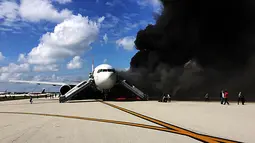 Penumpang dievakuasi dari pesawat Boeing 767-200ER milik maskapai Dynamic International Airways yang terbakar saat akan lepas landas di Bandara Fort Lauderdale, Florida, Kamis (29/10). 15 orang terluka akibat kejadian tersebut. (AFP PHOTO/Andres Gallego)