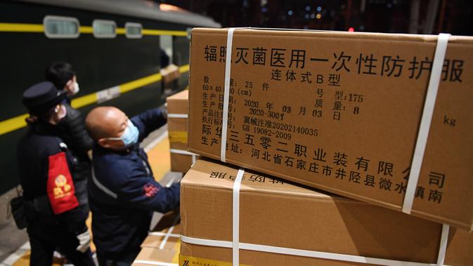 Para staf memuat sejumlah baju pelindung di Stasiun Kereta Barat Beijing di Beijing, ibu kota China (4/3/2020). Total 20.000 baju pelindung disalurkan ke Wuhan guna membantu upaya kota itu memerangi wabah coronavirus baru. (Xinhua/Zhang Chenlin)