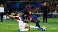 Pemain Olympiakos, Costinha (bawah), berusaha menghentikan pemain Barcelona, Alejandro Balde, dalam pertandingan fase pembuka Liga Champions antara Barcelona dan Olympiakos di Barcelona, Spanyol, Selasa, 21 Oktober 2025. (AP Photo/Joan Monfort)&nbsp;&nbsp;&nbsp;