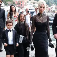 Kim Kardashian tampil nyentrik di hari pernikahan kakaknya itu. Perempuan 41 tahun itu tampil bergaya gothic mengenakan lace dress warna hitam. Gayanya disempurnakan dengan bros dan kalung choker, serta tata rambut high bun. (Instagram/enews).