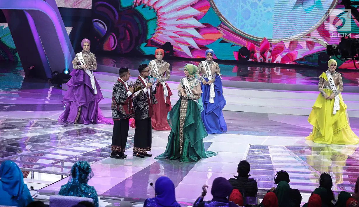 Finalis asal Indonesia berbincang dengan pembawa acara saat akan menjawab pertanyaan yang diajukan dewan juri dalam malam puncak Puteri Muslimah Asia 2018 di Jakarta, Senin (7/5). (Liputan6.com/Faizal Fanani)