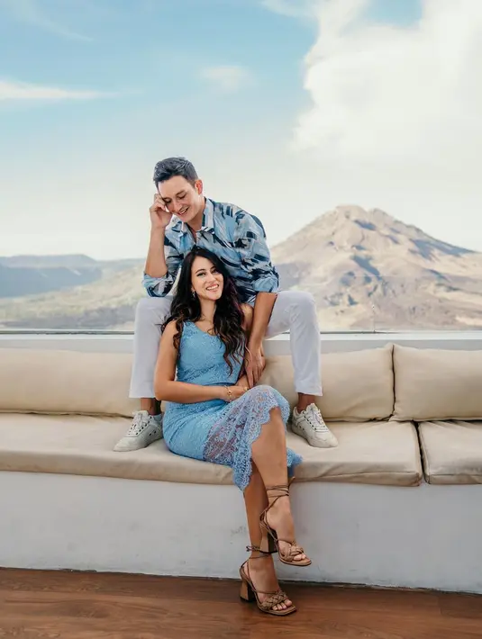 Berlatar Kintamani, pasangan ini kompak dengan nuansa biru. Mike mengenakan kemeja motif abstrak yang dipadukan dengan celana dan sneaker putih. Sedangkan Janisaa tampil simple dengan dress brukat dan wedges tan.(instagram/mikelewis)