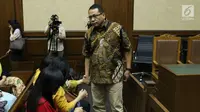Terdakwa suap pengadaan dan pelaksanaan pembangunan kampus IPDN Sumbar Kab Agam 2011, Dudy Jocom memegang tangan keluarganya usai sidang putusan di Pengadilan Tipikor Jakarta, Rabu (14/11). Dudy divonis 4 tahun penjara. (Liputan6.com/Helmi Fithriansyah)