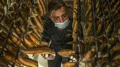 Seorang pekerja Palestina mengatur ikan asap di sebuah pabrik di Rafah di Jalur Gaza selatan pada 9 April 2023 untuk dijual di pasar menjelang liburan Idul Fitri yang menandai berakhirnya bulan puasa Ramadhan. (Photo by SAID KHATIB / AFP)