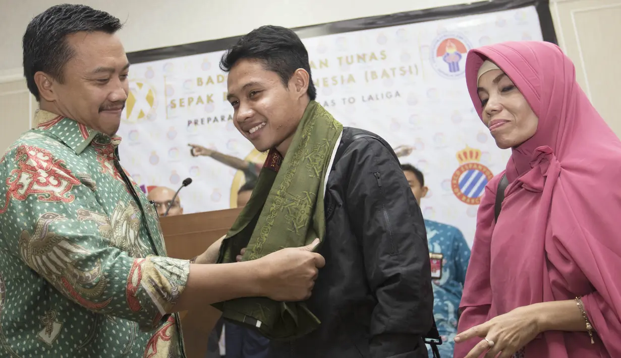 Pesepak bola Indonesia, Evan Dimas, menerima sarung dari Menpora, Imam Nahrawi. Sarung ini diberikan Menpora agar Evan tetap rajin menunaikan ibadah salat. (Bola.com/Vitalis Yogi Trisna)