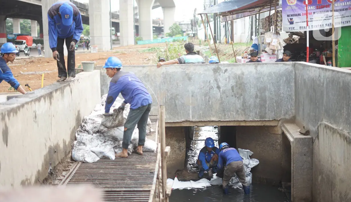 Petugas membersihkan saluran gorong-gorong air di Jalan DI Panjaitan, Kebon Nanas, Jakarta, Jumat (6/12/2019). Hal tersebut dilakukan guna mengantisipasi tersumbatnya saluran air selama memasuki periode musim hujan. (Liputan6.com/Immanuel Antonius)