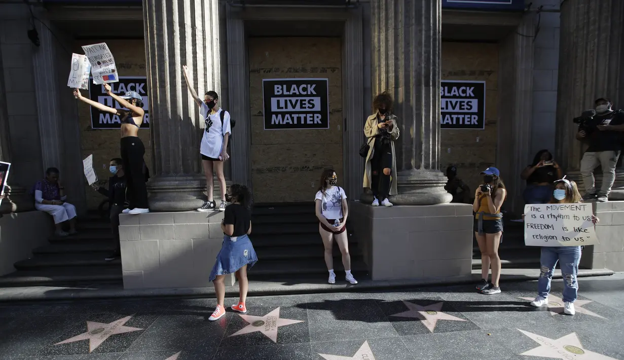 Pengunjuk rasa berdiri di sepanjang Hollywood Walk of Fame saat memprotes kematian George Floyd di Hollywood, Los Angeles, Amerika Serikat, Minggu (7/6/2020). Gelombang protes atas kematian George Floyd terus mengguncang Amerika Serikat. (AP Photo/Marcio Jose Sanchez)