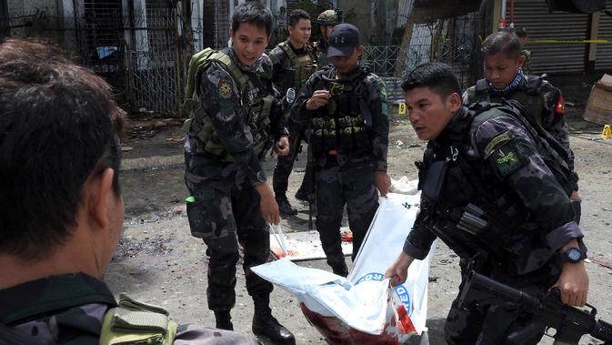 Polisi mengevakuasi kantong jenazah pasca ledakan bom di Gereja Katolik Jolo, Filipina Selatan, Minggu (27/1). Ledakan pertama terjadi tepat ketika Misa Minggu berlangsung, sekitar pukul 08.45 waktu setempat. (Nickee Butlangan/AFP)