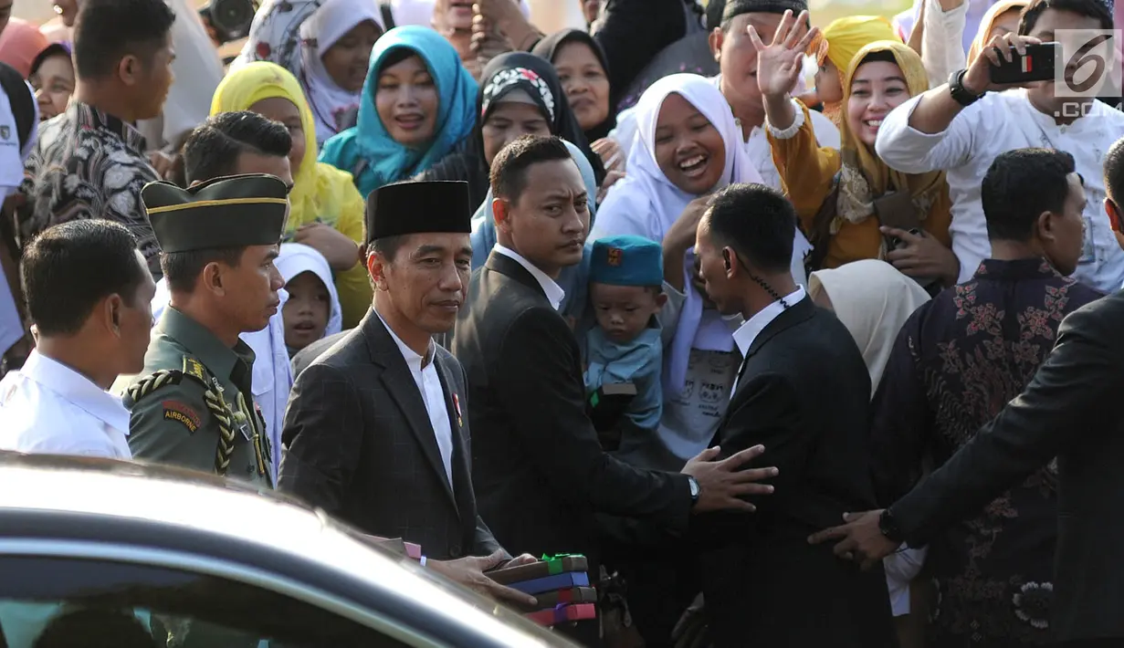 Presiden Joko Widodo atau Jokowi menyerahkan  buku kepada warga  usai  menunaikan salat Idul Adha 1439 Hijriah di Lapangan Tegar Beriman, Cibinong, Kabupaten Bogor, Jawa Barat, Rabu (22/08). (Merdeka.com/Arie Basuki)