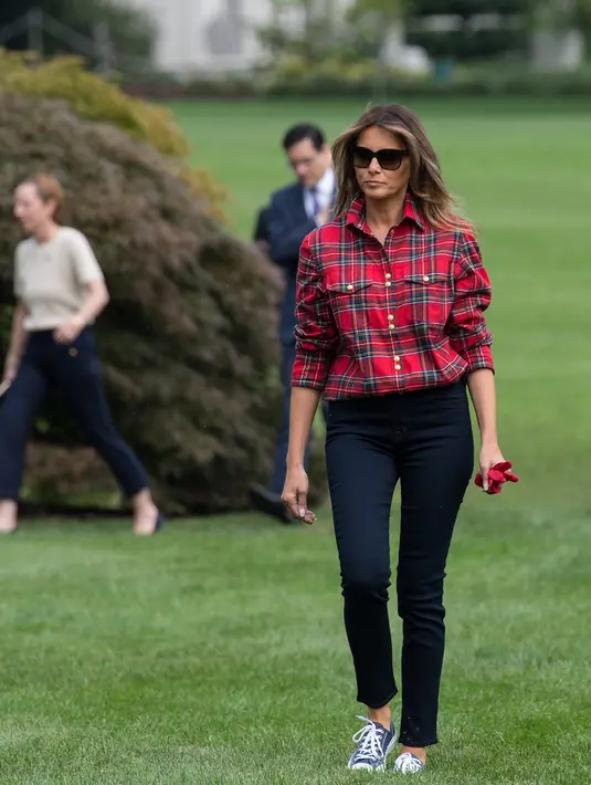 Ibu Negara AS, Melania Trump bersiap berkebun bersama anak-anak dari Boys & Girls Club di Kitchen Garden Gedung Putih, Jumat (22/9). Ibu satu anak ini memakai sepatu converse warna abu-abu dan bercelana jeans skinny warna hitam. (NICHOLAS KAMM/AFP)
