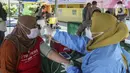 Warga menjalani pemeriksaan kesehatan saat mengikuti vaksinasi booster COVID-19 di Taman Pemuda Pratama, Depok, Jawa Barat, Kamis (7/4/2022). Bagi warga yang sudah vaksin dua kali masih perlu tes antigen, dan yang sudah vaksin booster lengkap tidak perlu tes apa-apa. (Liputan6.com/Johan Tallo)