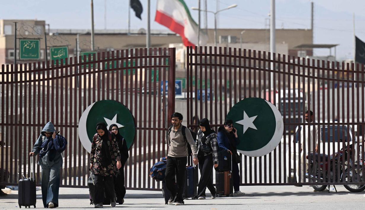 Warga Pakistan berjalan melintasi perbatasan Taftan, di provinsi Balochistan, Iran pada Selasa 3 Maret 2026, di tengah serangan Amerika Serikat dan Israel yang terus memanas. (Banaras KHAN/AFP)