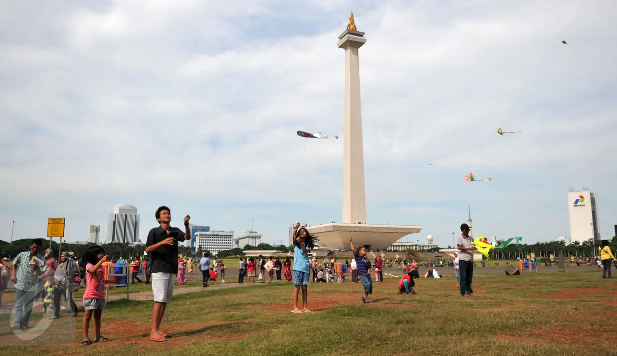 Sejumlah pengunjung bermain layang-layang di kawasan Monas, Jakarta, Sabtu (26/12/2015). Libur Natal dimanfaatkan sejumlah warga untuk berwisata ke tempat yang menjadi ikon Jakarta tersebut. (Liputan6.com/Yoppy Renato)