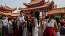 Pasangan pengantin baru keturunan Tionghoa  berciuman seusai acara pernikahan massal di Kuil Thean Hou, Kuala Lumpur, Senin (9/9/2019). Upacara pernikahan massal diadakan untuk 99 pasangan pada hari kesembilan bulan kesembilan yang dianggap sebagai tanggal keberuntungan. (Mohd RASFAN / AFP)