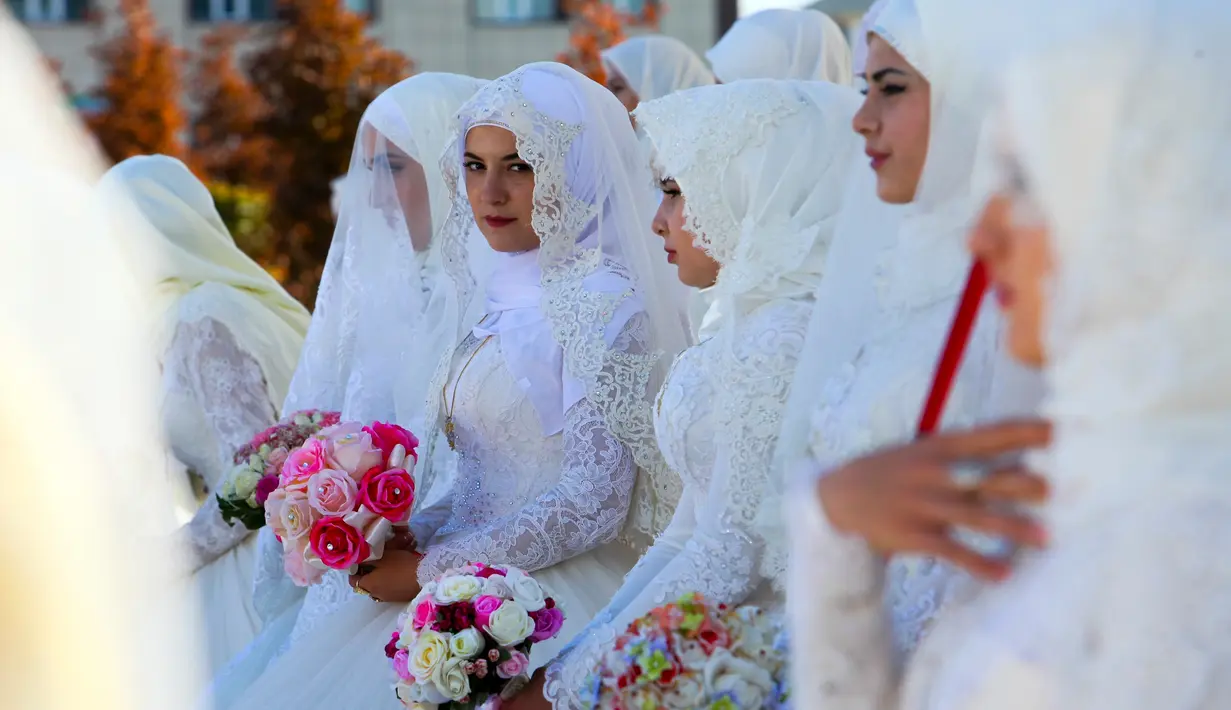 Mempelai perempuan menunggu prosesi pernikahan pada perayaan Rusia City Day di Grozny, Rusia, (5/10). Sebanyak 199 pasangan menikah di Taman Bunga Grozny pada perayaan tersebut. (AP Photo / Musa Sadulayev)