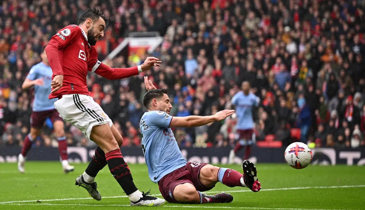 Pemain MU, Bruno Fernandes (kiri), menendang bola ke gawang Aston Villa yang membuahkangol dalam pertandingan pekan ke-34 Liga Inggris 2022/2023 yang berlangsung di Old Trafford, Minggu (30/4/2023). (AFP/Oli Scarff)