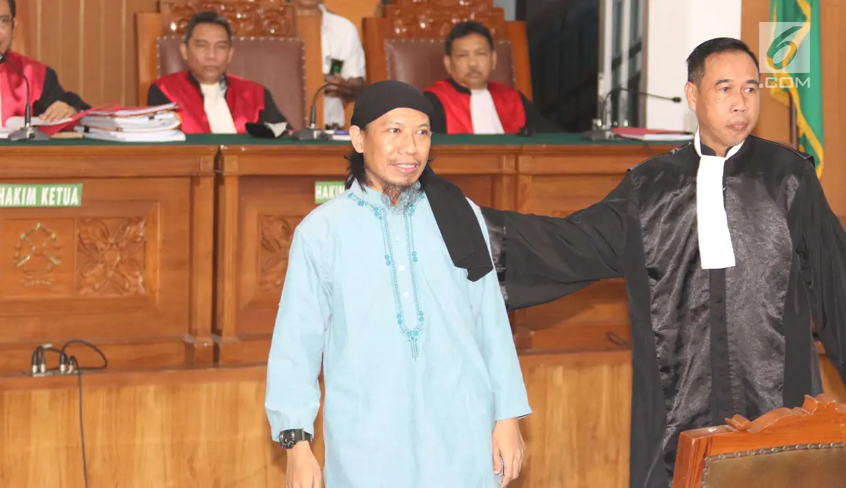 Terdakwa kasus teror bom Thamrin, Aman Abdurrahman bersiap menjalani sidang pembacaan vonis di Pengadilan Negeri Jakarta Selatan, Jumat (22/6). Aman Abdurrahman hadir dengan pengawalan ketat satuan kepolisian bersenjata lengkap (Liputan6.com/Angga Yuniar)